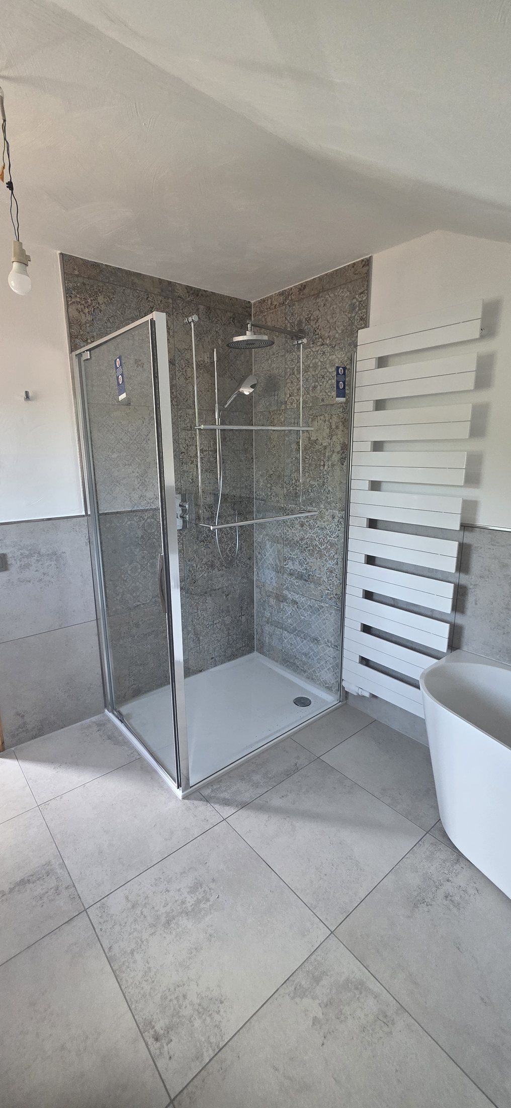 Badezimmer mit Badewanne und gefliestem Duschbereich